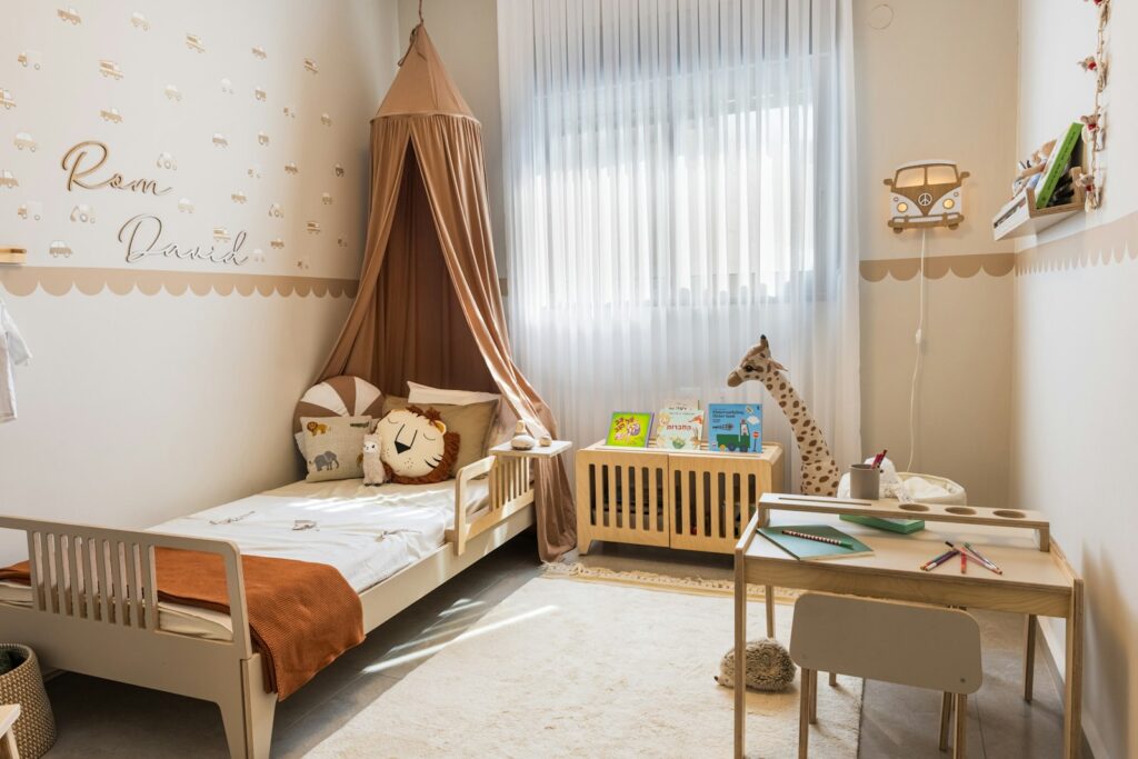 Chambre d’enfant chaleureuse : ciel de lit, tapis épais, voilage et applique murale allumée